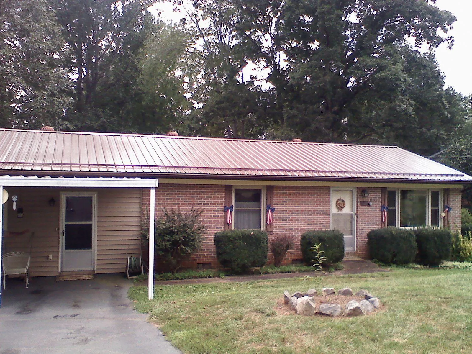 Bronze metal roof and carport on a brick ranch home — Roof Repair work by our crew in Cowpens
