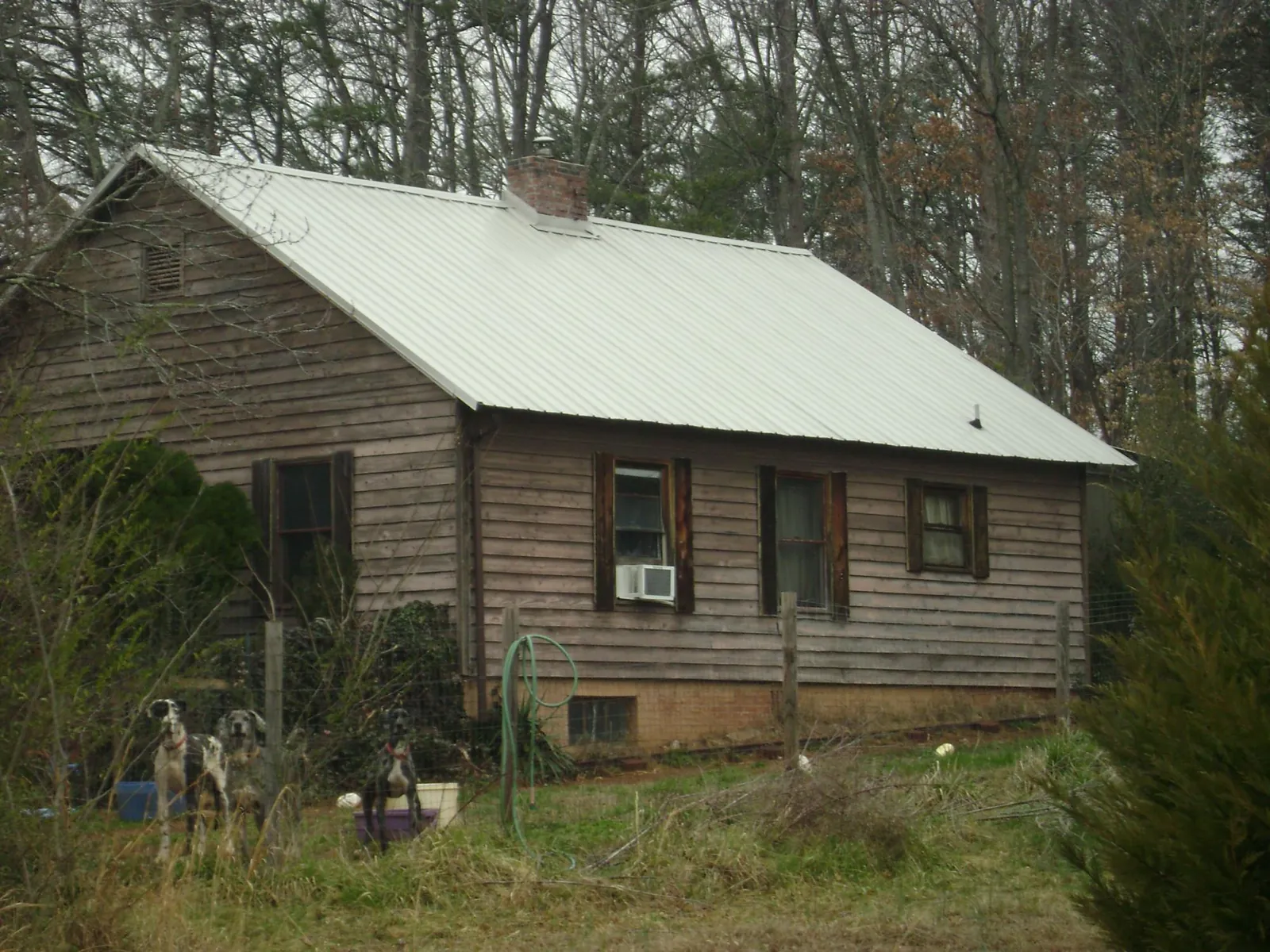 White metal roof on an old wood sided farmhouse, from a Metal Roof Installation job in Cowpens